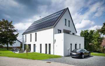 Die großen Solarthermie- und Photovoltaikanlagen auf dem Dach dieses Sonnenhauses erzeugen Energie für Wärme, Strom und Elektromobilität. Foto: Sonnenhaus-Institut / Udo Geisler